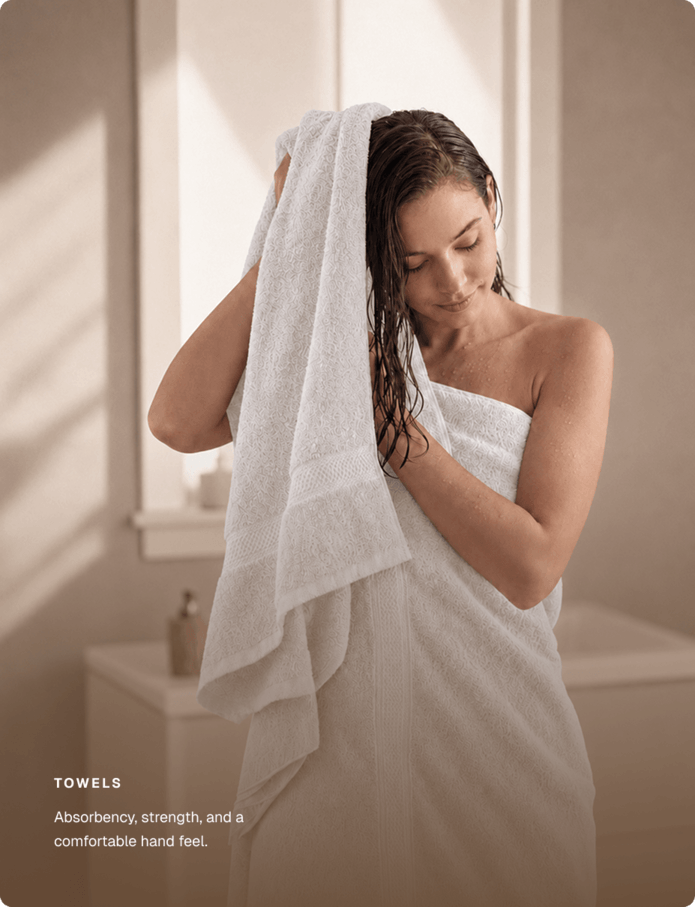 Woman wrapped in a white towel drying her hair