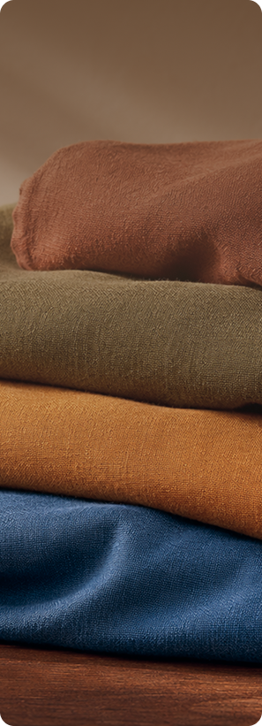 Stacked cotton textiles in warm colors and blue
